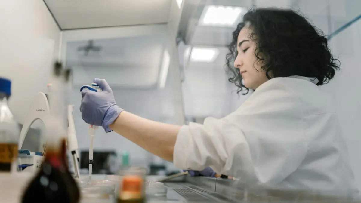Wissenschaftlerin, die in einem Labor eine Probe bearbeitet.